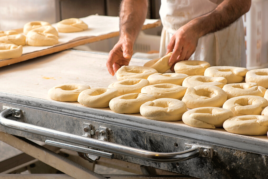 Baker hands making bread donuts